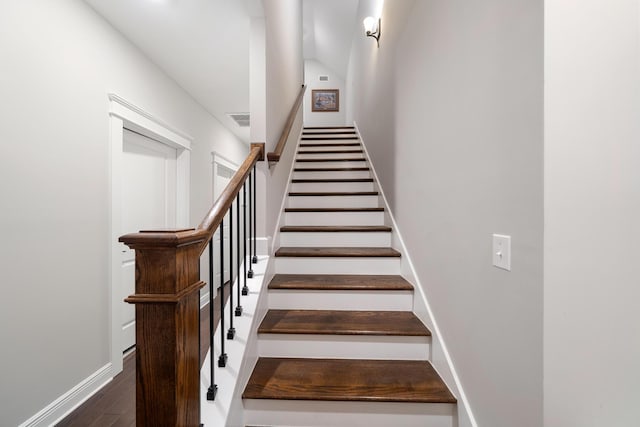 stairs with wood finished floors, visible vents, and baseboards