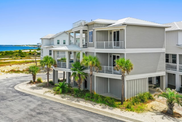 view of front of property featuring a balcony and a water view