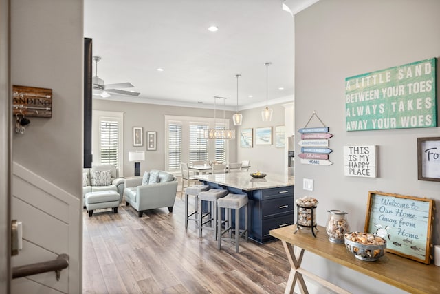 dining space with ceiling fan with notable chandelier, crown molding, and hardwood / wood-style flooring