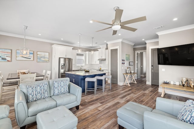 living room featuring ornamental molding, wood-type flooring, sink, and ceiling fan