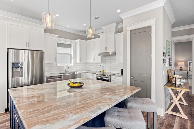 kitchen featuring a center island, stainless steel appliances, a breakfast bar, and white cabinets