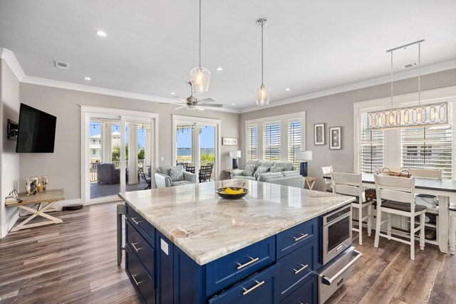 kitchen with blue cabinets, dark wood-type flooring, a kitchen island, and ceiling fan