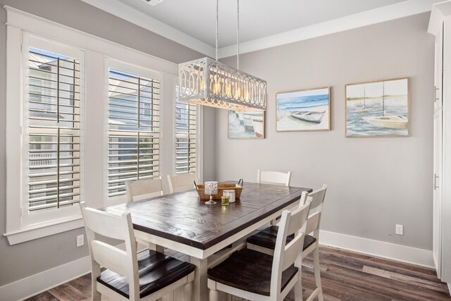 dining room featuring ornamental molding and dark hardwood / wood-style floors