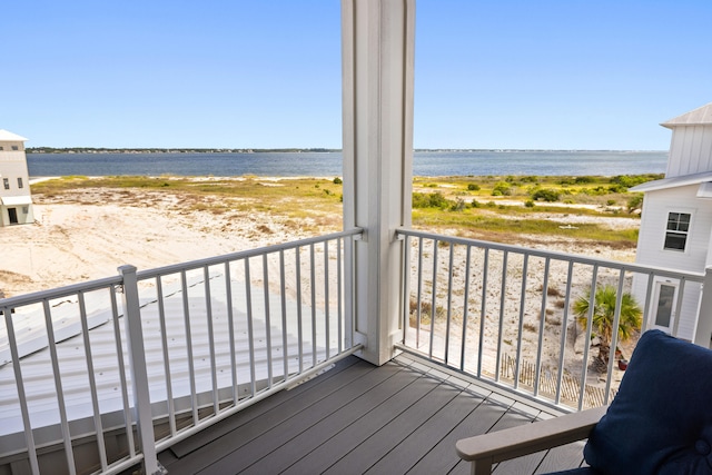 balcony featuring a view of the beach and a water view