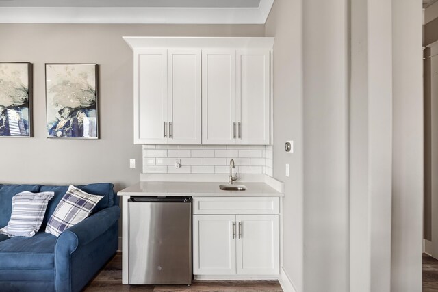 bar featuring white cabinetry, backsplash, sink, and dark hardwood / wood-style floors