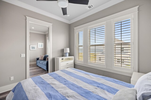 bedroom featuring crown molding, dark wood-type flooring, and ceiling fan