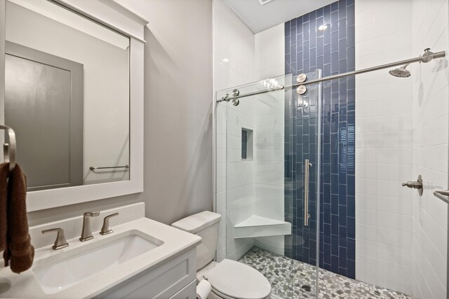 bathroom featuring vanity, toilet, and an enclosed shower