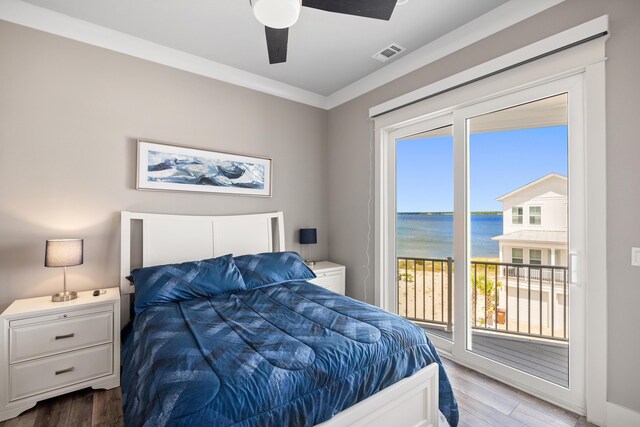 bedroom featuring a water view, ceiling fan, hardwood / wood-style flooring, and access to exterior