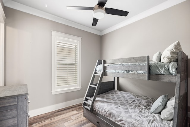 bedroom with light wood-type flooring, crown molding, and ceiling fan