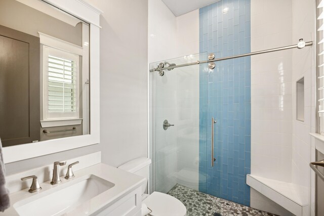 bathroom featuring vanity, toilet, and a shower with shower door