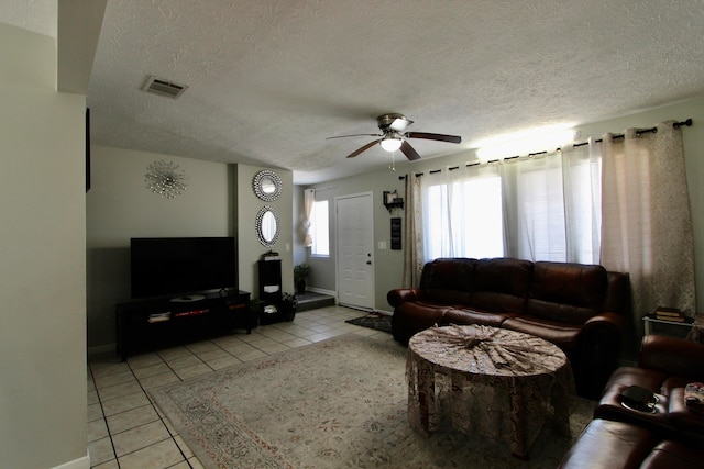 tiled living room with ceiling fan and a textured ceiling