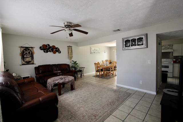 tiled living room with a textured ceiling and ceiling fan