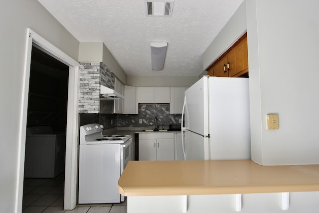 kitchen featuring white cabinetry, sink, backsplash, light tile patterned floors, and white appliances