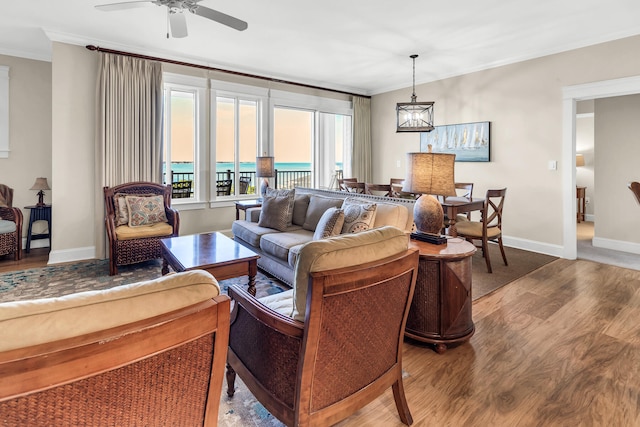 living room with crown molding, wood-type flooring, and ceiling fan