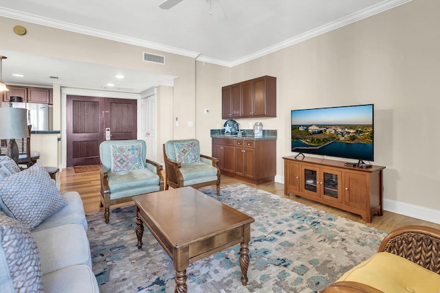 living room featuring light wood-type flooring, crown molding, and ceiling fan