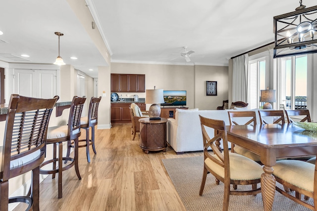 dining space featuring light wood-type flooring, crown molding, and ceiling fan