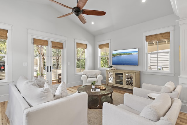 living room featuring ceiling fan, decorative columns, vaulted ceiling, and light wood-type flooring