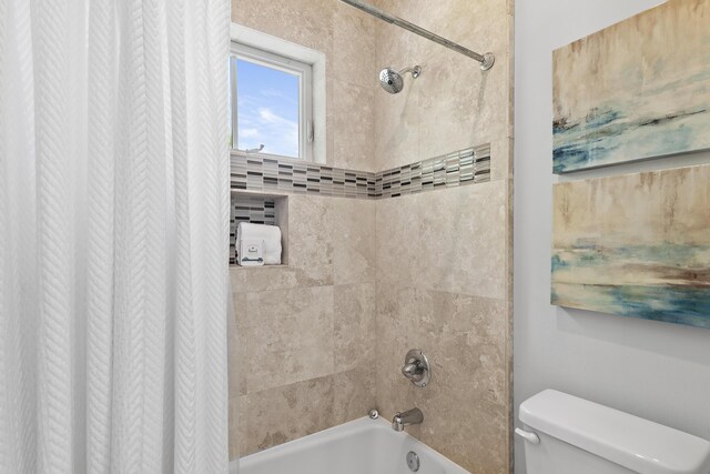 bathroom featuring shower / bath combo with shower curtain and toilet