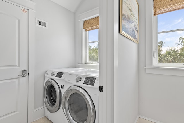 laundry area with washing machine and clothes dryer and a wealth of natural light