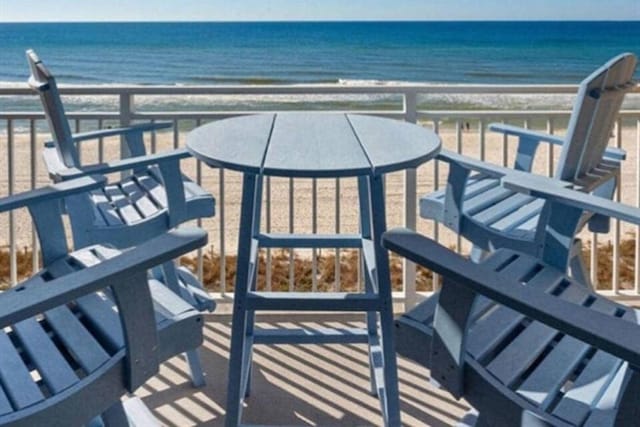 balcony featuring a water view and a beach view