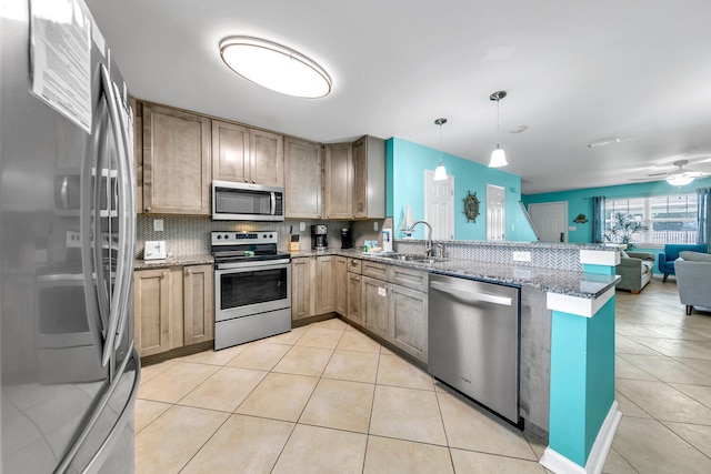 kitchen featuring hanging light fixtures, stainless steel appliances, sink, kitchen peninsula, and ceiling fan