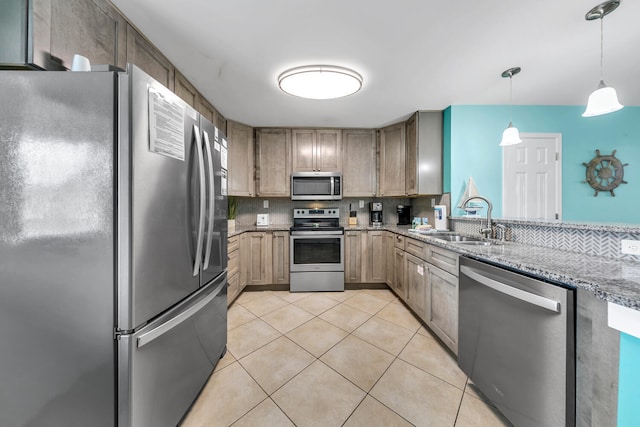 kitchen featuring decorative light fixtures, light tile patterned floors, stainless steel appliances, sink, and light stone counters