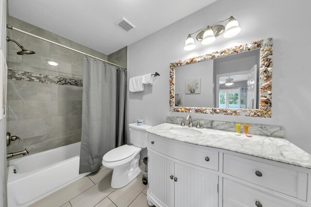 full bathroom with toilet, tile patterned flooring, vanity, ceiling fan, and shower / tub combo with curtain