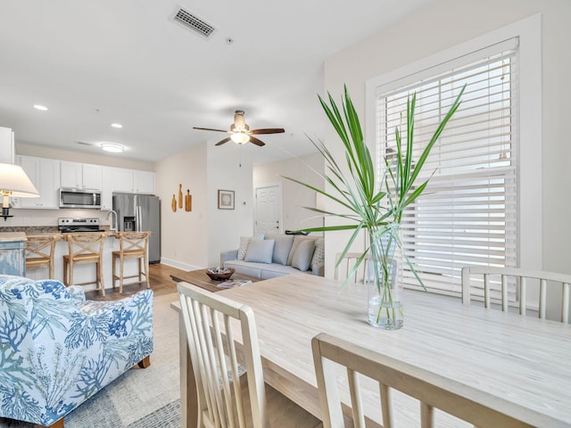 dining space featuring baseboards, visible vents, recessed lighting, ceiling fan, and light wood-style floors