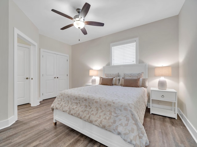 bedroom with ceiling fan, a closet, baseboards, and wood finished floors