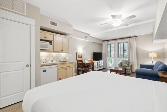 bedroom featuring ceiling fan, sink, and light hardwood / wood-style flooring