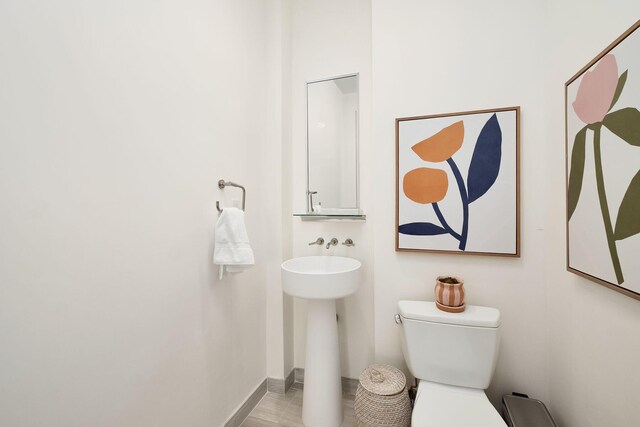 bathroom with toilet and hardwood / wood-style flooring