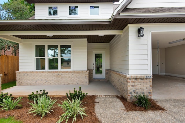 601 Third Ave, Destin, FL 32541 - view of exterior entry featuring brick siding and a porch
