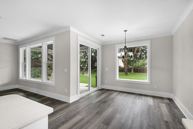 unfurnished dining area featuring a healthy amount of sunlight, an inviting chandelier, and dark hardwood / wood-style floors