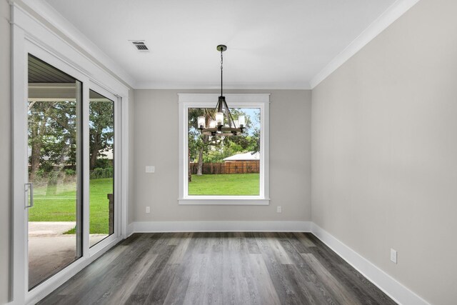 unfurnished dining area featuring dark hardwood / wood-style flooring, an inviting chandelier, and a healthy amount of sunlight