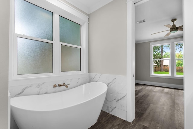 601 Third Ave, Destin, FL 32541 - bathroom featuring wood finished floors, visible vents, a freestanding tub, ornamental molding, and wainscoting