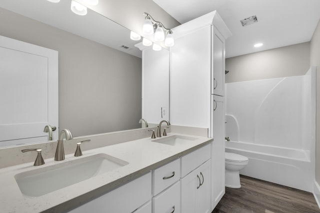 full bathroom with vanity, toilet, hardwood / wood-style flooring, and tub / shower combination