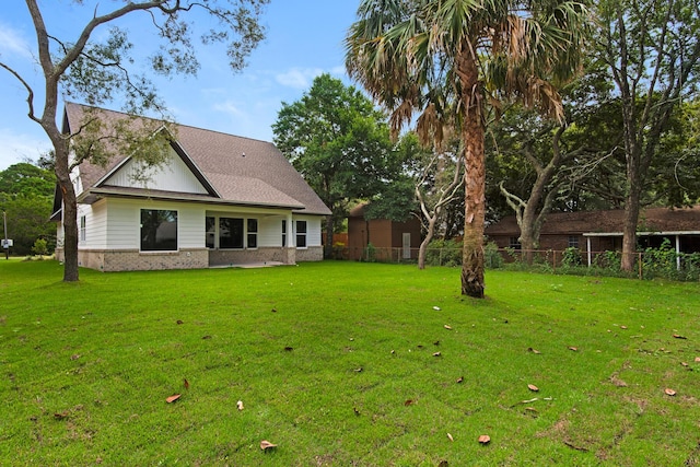 601 Third Ave, Destin, FL 32541 - rear view of house with brick siding, a shingled roof, a yard, and fence