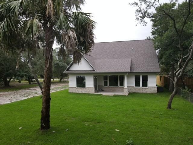 601 Third Ave, Destin, FL 32541 - back of house with a lawn, roof with shingles, driveway, and fence