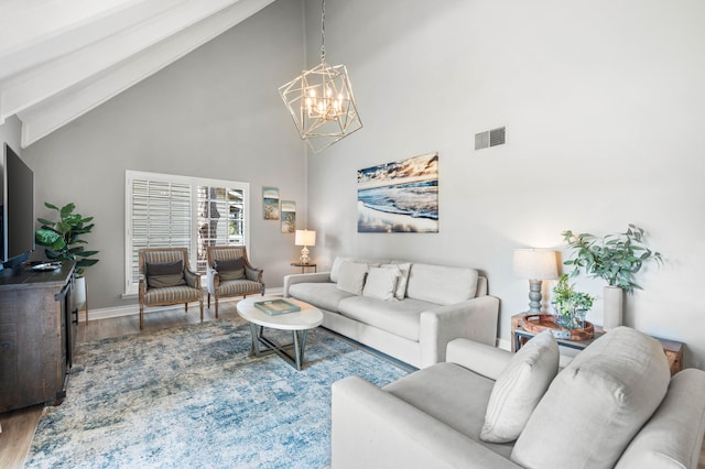 living room with hardwood / wood-style floors, high vaulted ceiling, and a notable chandelier