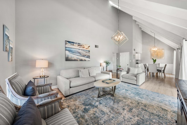 living room with hardwood / wood-style floors, high vaulted ceiling, and an inviting chandelier