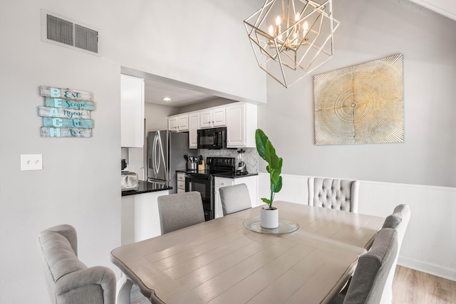 dining area with an inviting chandelier and light hardwood / wood-style floors