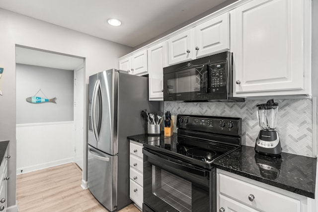 kitchen with dark stone counters, tasteful backsplash, light hardwood / wood-style flooring, black appliances, and white cabinets