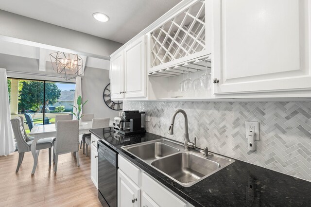 kitchen featuring white cabinets, black dishwasher, a chandelier, and sink