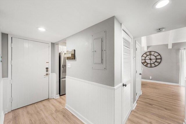 hall featuring electric panel and light hardwood / wood-style floors