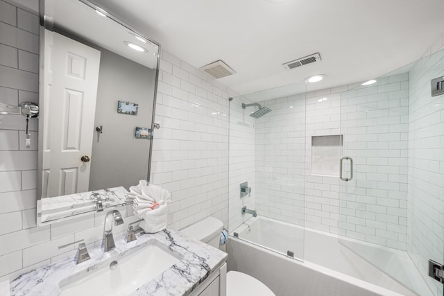 full bathroom with shower / bath combination with glass door, vanity, and toilet