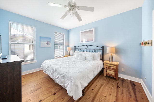 bedroom with baseboards, ceiling fan, and light wood finished floors