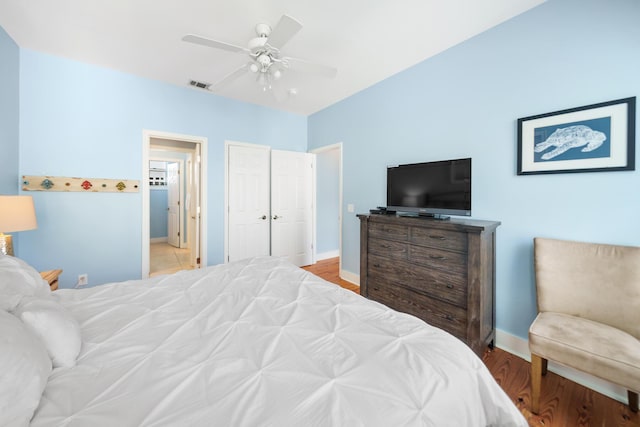 bedroom featuring wood finished floors, baseboards, visible vents, and ceiling fan