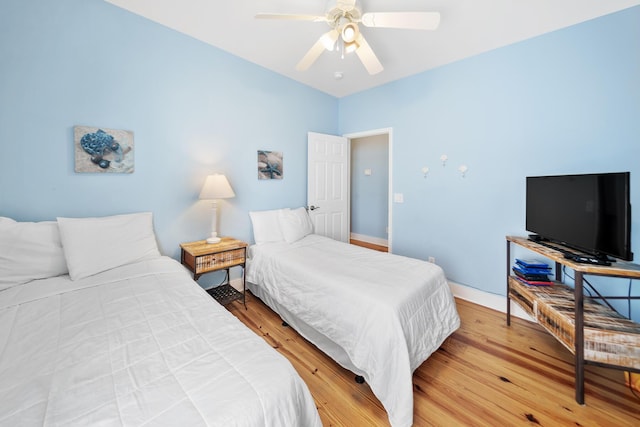 bedroom with light wood-style floors, baseboards, and ceiling fan