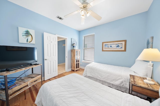 bedroom featuring visible vents, baseboards, ceiling fan, and wood finished floors