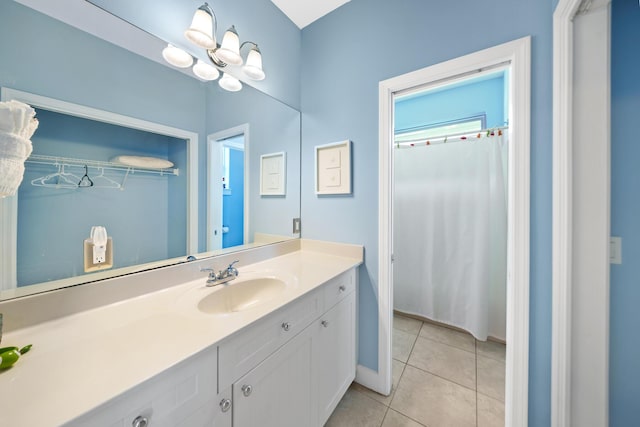 bathroom with tile patterned flooring, an inviting chandelier, and vanity